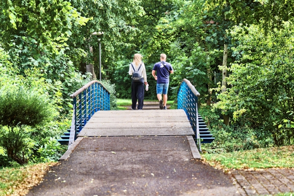 Zwei Personen gehen beim Spazieren über eine Brücke